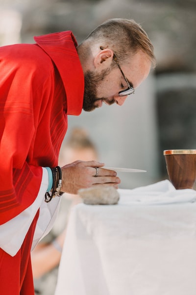 一个穿着红色长袖衬衫拿着棕色陶瓷杯的男人